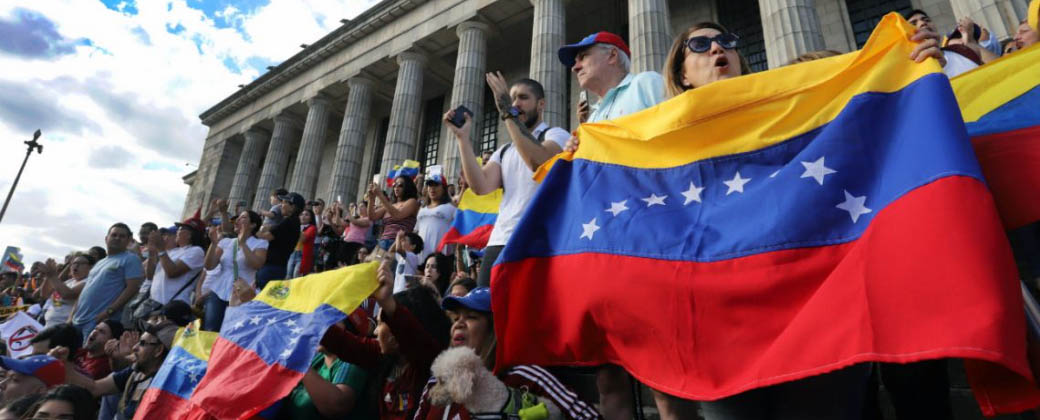 Parte de la población venezolana en Argentina agitando banderas de su país en las escalinatas de la facultad de Derecho de la UBA.