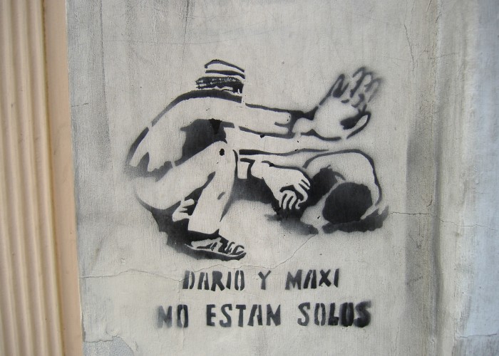 Graffiti que hace referencia al momento en que Santillán socorre a Kosteki y levanta la mano para que la policía no dispare. Créditos: Wikipedia