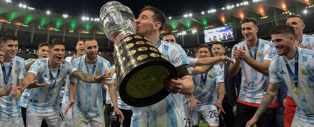 Ante la mirada de sus compañeros, Messi besa la Copa América. Créditos: AFP