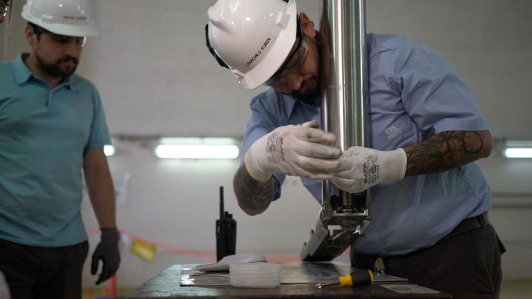 Trabajadores de Nucleoeléctrica Argentina con una herramienta de acero que permitirá la extracción del separador.