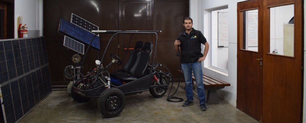 El ingeniero Nicolás Brizzio posa al lado del auto biplaza en el Laboratorio de Electromivilidad. Créditos: FIO-UNICEN