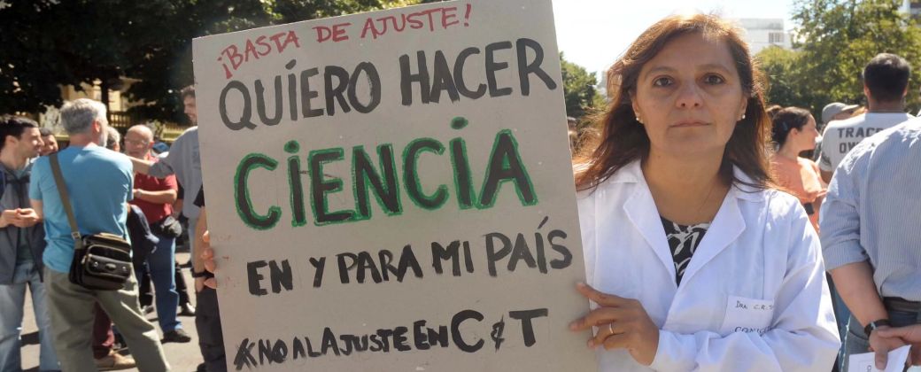 Una científica posa con un cartel contra el ajuste en Ciencia y Tecnología. Créditos: Revista veintitrés.