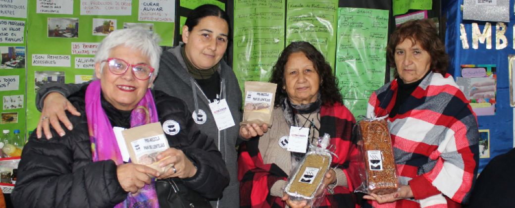 Las integrantes de Cocinando sueños posan con sus panes y premezclas de lentejas y garbanzos. Créditos: Nicolás Retamar / Agencia de Noticias Científicas UNQ.