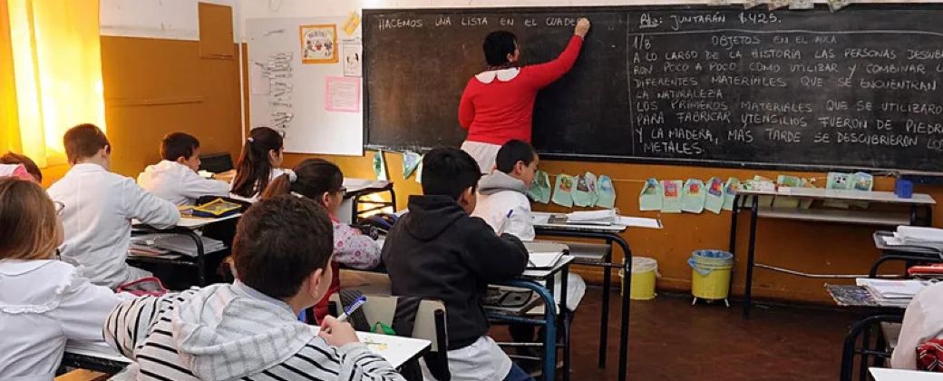 Una maestra copia en el pizarrón mientras los estudiantes copian. Créditos: C5N.