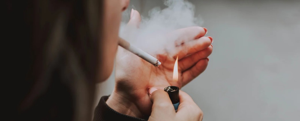 Mujer fumando un cigarrillo.