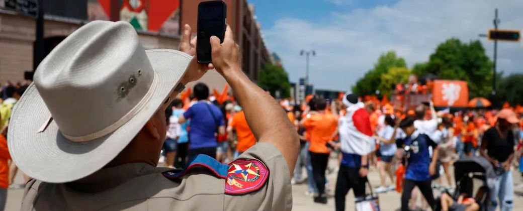 Un policía filma a hinchas holandeses en la previa del partido contra Japón. Créditos: EFE / Sebastián Mariscal.